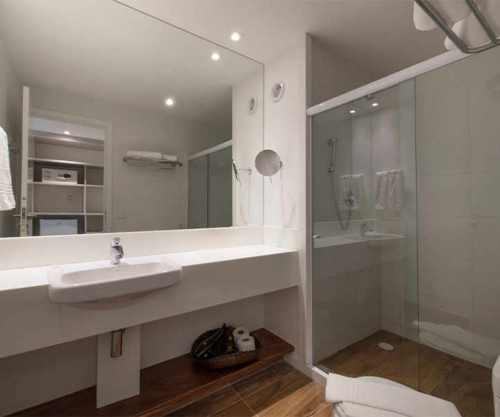 Banheiro do Quarto Smart, com pia moderna, box de vidro e área bem iluminada.